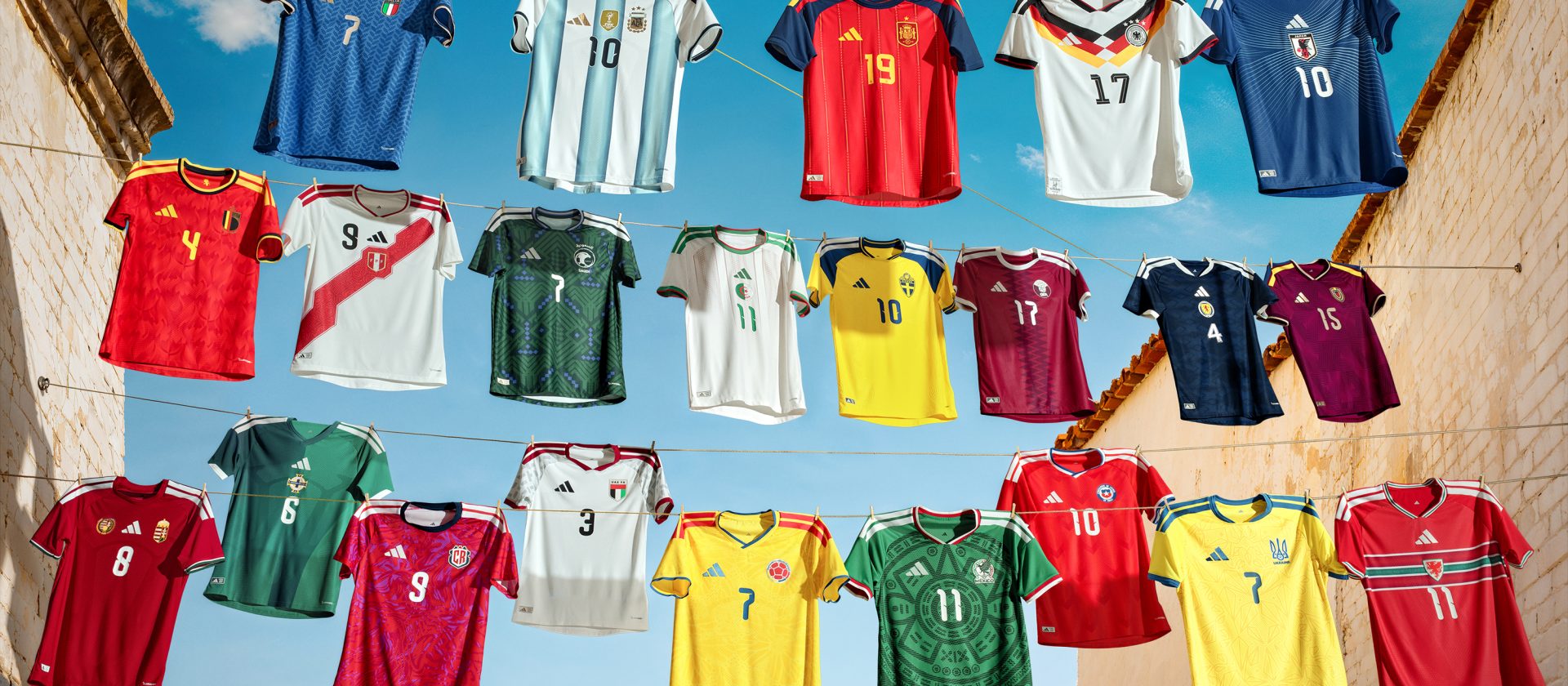 Camisetas de selecciones nacionales colgadas en cuerdas bajo un cielo azul